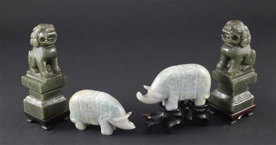 A pair of Chinese spinach green jade lion-dogs and a pair of jadeite figures of elephants, 20th century, 9.5cm, one wood stand